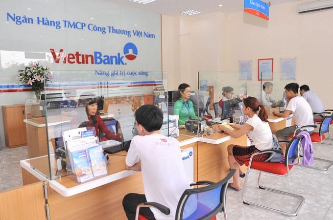 Hình ảnh minh họa khách hàng đang thực hiện giao dịch tại quầy trong chi nhánh ngân hàng