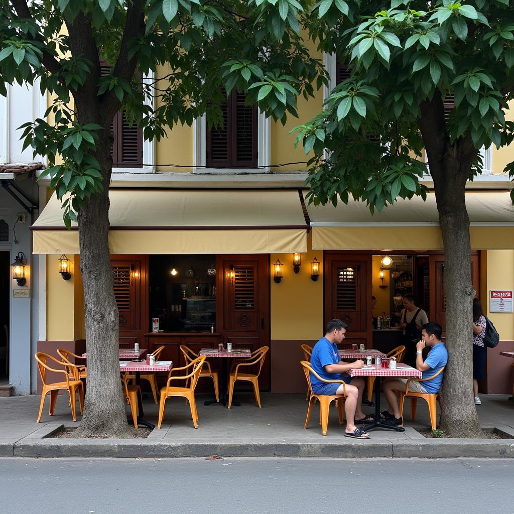 Một góc quán cà phê vỉa hè đặc trưng ở Phường Xuân Hòa, Quận 3, TP Hồ Chí Minh với bàn ghế nhỏ và cây xanh