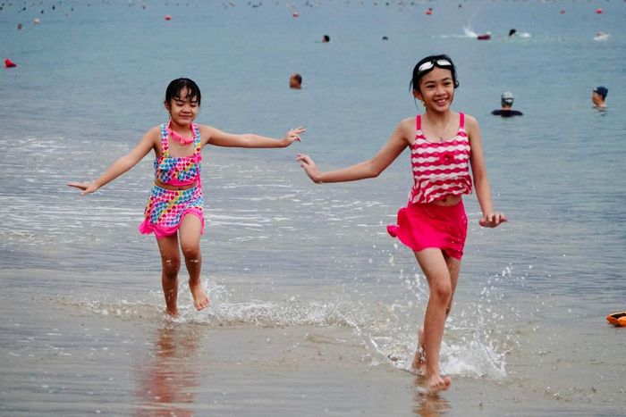 Du khách thư giãn tắm biển Nha Trang, mẹo du lịch tự túc an toàn