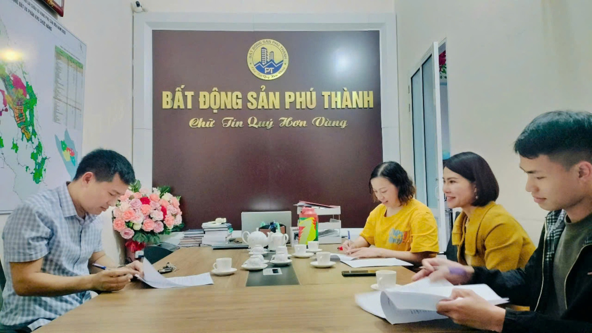 Khách hàng và nhân viên giao dịch Công ty TNHH MTV Bất động sản Phú Thành ký kết hợp đồng mua bán nhượng quyền sử dụng đất.