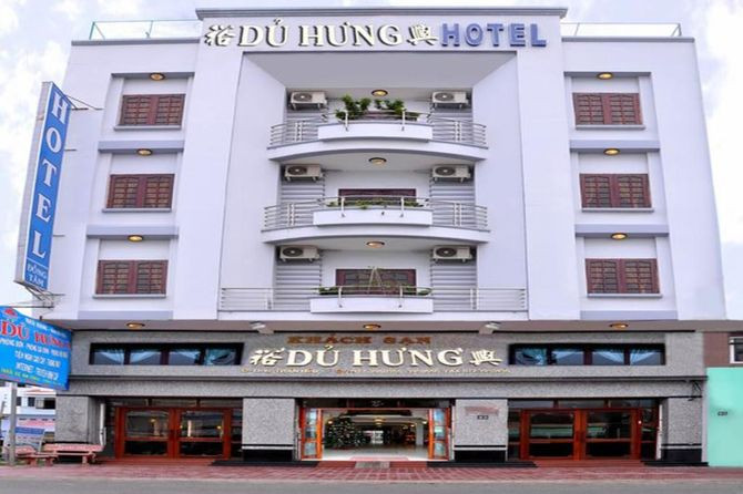 Khách sạn Dủ Hưng Hà Tiên nhìn từ bên ngoài, hiển thị kiến trúc hiện đại và lối vào thân thiện