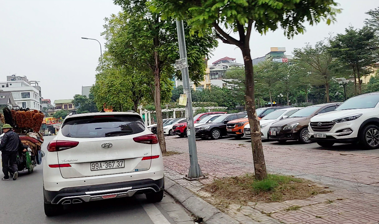 Một góc Vườn hoa Bồ Đề Xanh ở Long Biên và lòng đường đối diện Bệnh viện Đa khoa Tâm Anh bị xe chiếm dụng