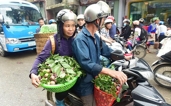 Người dân gùi mận tam hoa từ đồi xuống thị trấn Bắc Hà để bán vào buổi sáng sớm