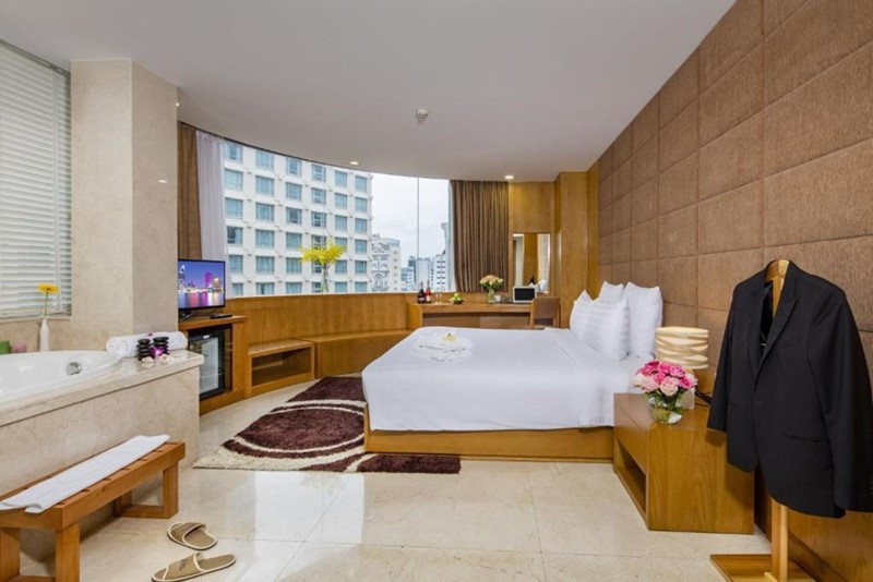 Phòng Suite Executive tại khách sạn Paradise Saigon Boutique Hotel &amp; Spa với phòng khách sang trọng và tầm nhìn đô thị