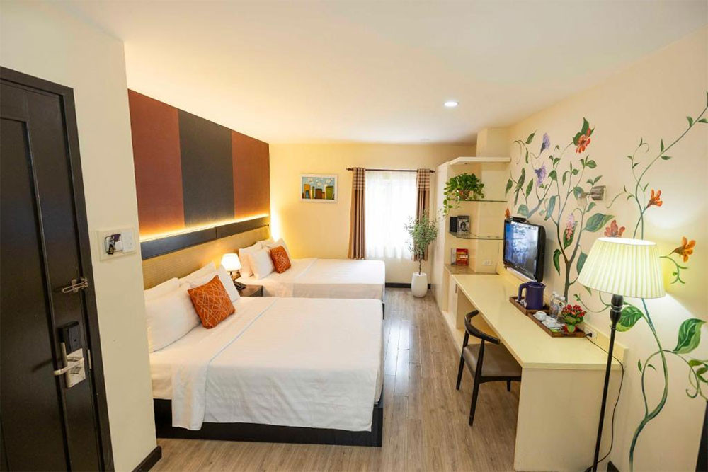 Phòng nghỉ ấm cúng tại Asian Ruby Hotel &amp; Apartment với nội thất gỗ, giường đôi thoải mái và không gian sạch sẽ, mang lại trải nghiệm dễ chịu cho du khách tại khách sạn 3 sao quận 1 Asian Ruby Hotel &amp; Apartment
