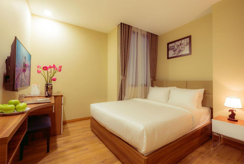 Phòng nghỉ hiện đại tại A25 Hotel với giường đôi lớn, TV treo tường và không gian gọn gàng, mang lại sự tiện nghi và thoải mái cho du khách tại khách sạn 3 sao quận 1 A25 Hotel