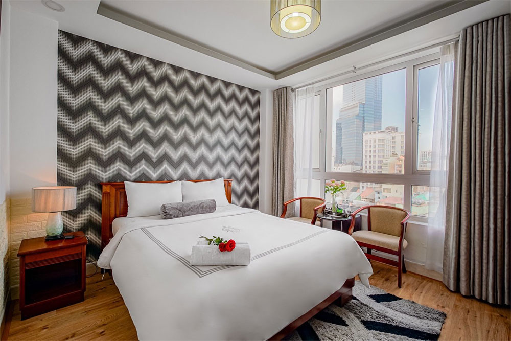 Phòng nghỉ hiện đại tại Ace Hotel Ben Thanh với tông màu xám trang nhã, giường thoải mái và không gian gọn gàng, mang lại sự tiện nghi cho du khách tại khách sạn 3 sao quận 1 Ace Hotel Ben Thanh