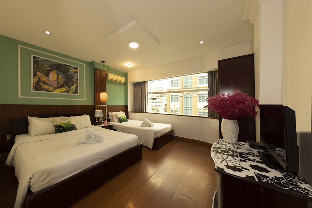 Phòng nghỉ sạch sẽ tại khách sạn Vinion Central &amp; Spa với tông màu sáng, giường thoải mái và cửa sổ đón sáng, mang lại không gian dễ chịu cho du khách tại khách sạn 3 sao quận 1 Vilion Central &amp; Spa