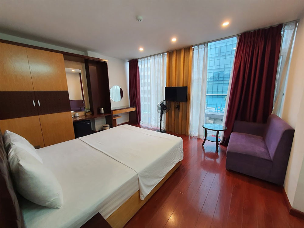 Phòng nghỉ tại Thuy Sakura Hotel &amp; Serviced Apartment với giường đơn thoải mái, bàn làm việc và cửa sổ đón sáng, mang lại không gian sạch sẽ và tiện nghi tại khách sạn 3 sao quận 1 Thuy Sakura Hotel &amp; Serviced Apartment