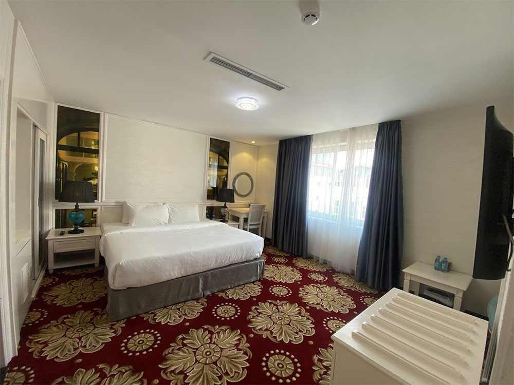 Phòng nghỉ tiện nghi tại California Saigon Hotel, với giường lớn, TV treo tường và cửa sổ đón ánh sáng tự nhiên, mang lại không gian thoải mái cho du khách tại khách sạn 3 sao quận 1 California Saigon Hotel