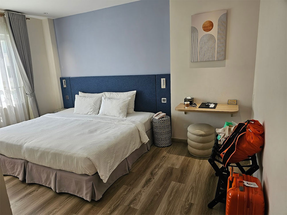 Phòng nghỉ tiện nghi tại Jovia Hotel, với tông màu trung tính và cửa sổ lớn đón ánh sáng tự nhiên, tạo không gian thoải mái cho du khách tại khách sạn 3 sao quận 1 Jovia Hotel