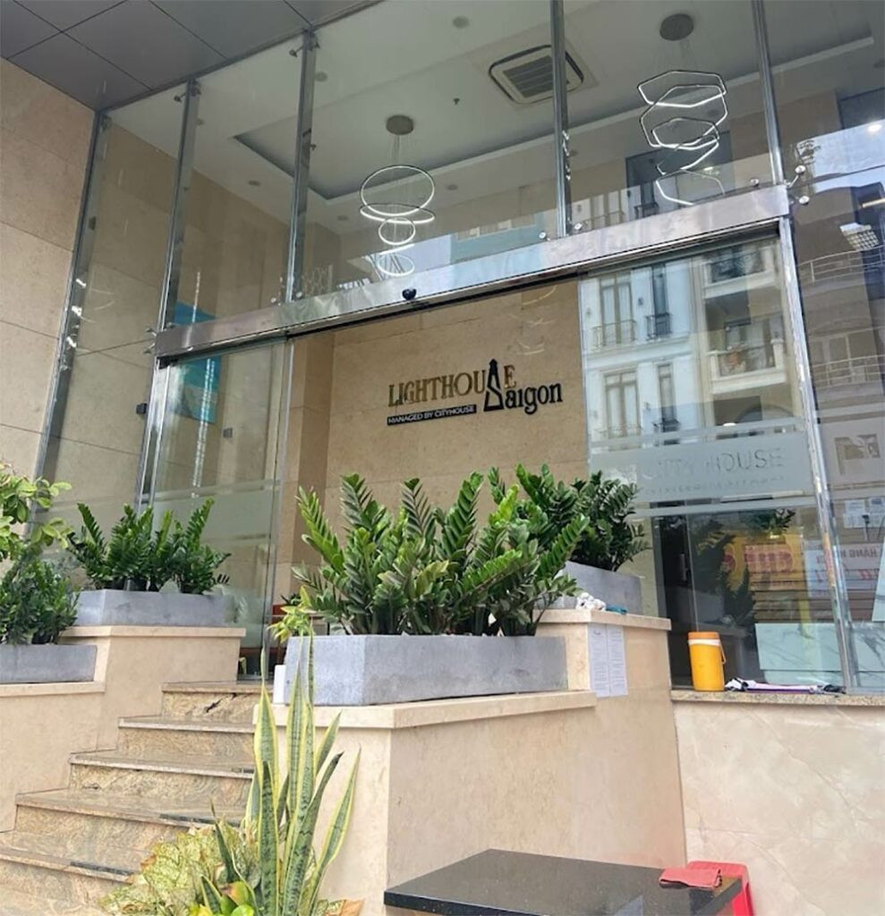 Sảnh bên ngoài của Cityhouse - LightHouse SG với kiến trúc độc đáo, biển hiệu màu sắc nổi bật và không gian xanh, thu hút ánh nhìn của du khách tại khách sạn 3 sao quận 1 Cityhouse – LightHouse SG