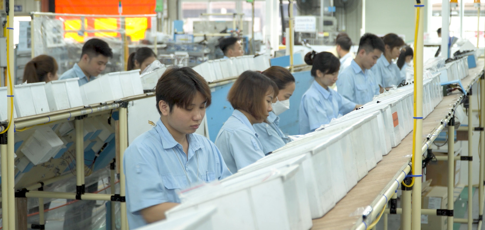 Dây chuyền sản xuất được điều khiển tự động với công nhân đang giám sát, thể hiện sự kết hợp giữa công nghệ và lao động tại Sumi Hanel
