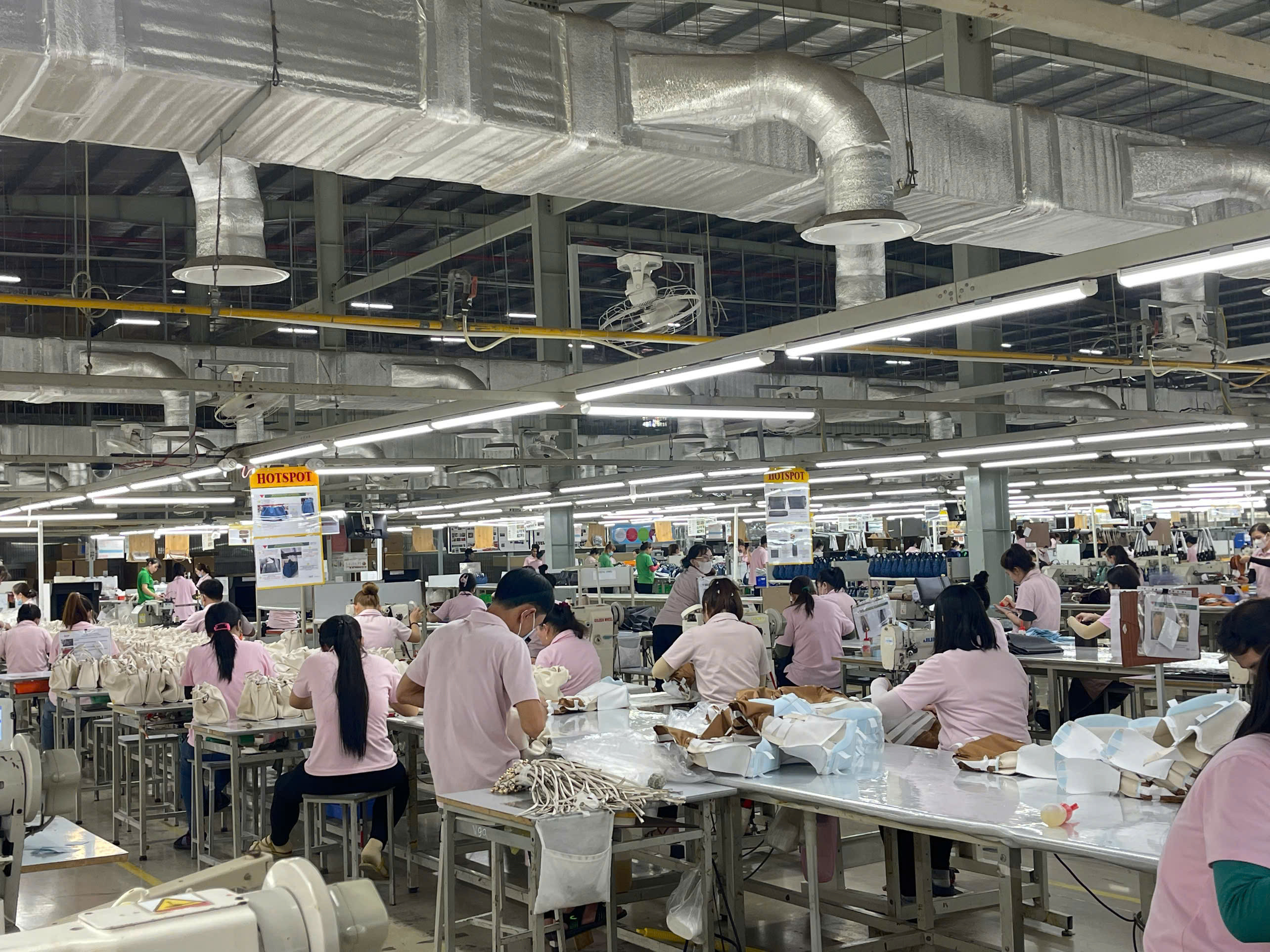 Công nhân đang thực hiện công đoạn làm quai túi xách tại xưởng sản xuất của CÔNG TY TNHH TÚI XÁCH SIMONE VIỆT NAM