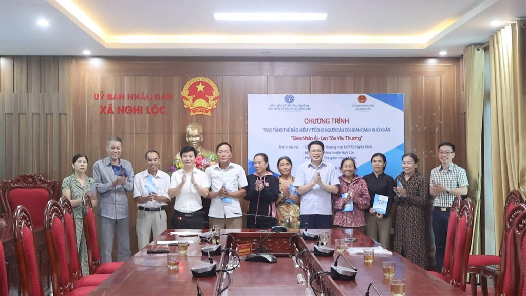 Cảnh trao thẻ bảo hiểm y tế, thể hiện các hoạt động an sinh xã hội và sự quan tâm đến phúc lợi cộng đồng của Công ty TNHH May Thời trang Perseption USA